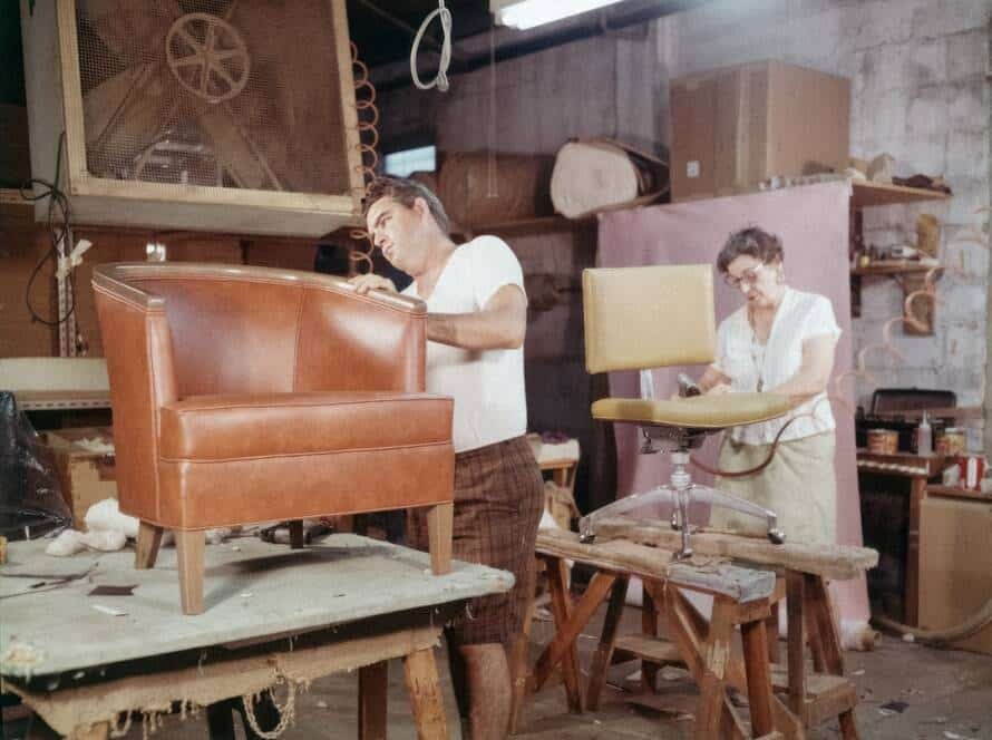 Un artisan restaure minutieusement un meuble en bois ancien dans son atelier