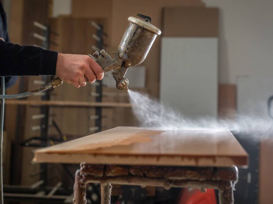 Un artisan qui restaure un meuble moderne en atelier