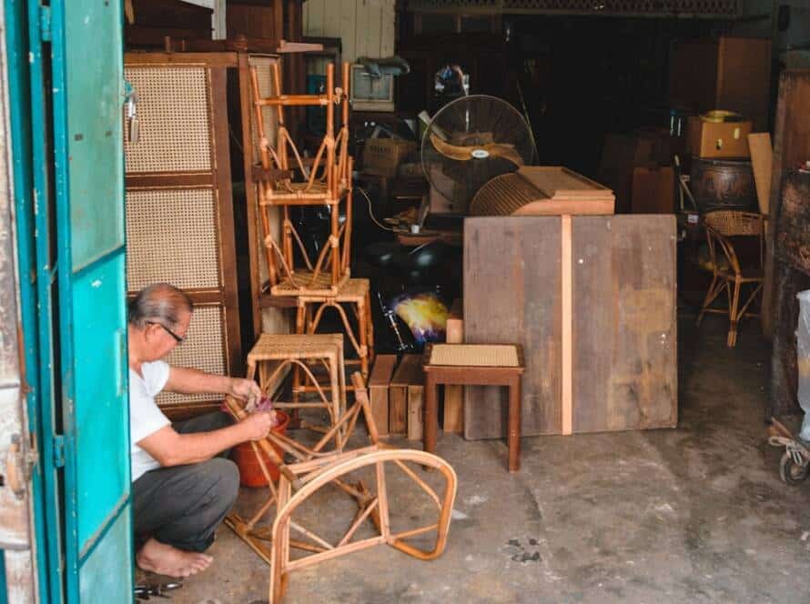 Artisan à l’œuvre sur la restauration écologique d’un meuble en atelier.